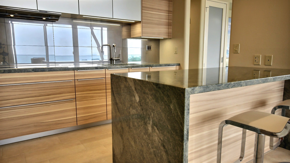 Inspiration for a contemporary eat-in kitchen in Hawaii with an undermount sink, flat-panel cabinets, medium wood cabinets, granite benchtops, porcelain splashback and stainless steel appliances.