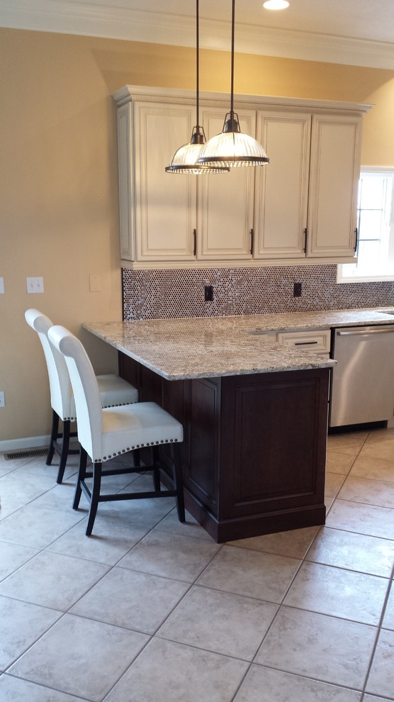 This is an example of a mid-sized traditional u-shaped eat-in kitchen in Chicago with a farmhouse sink, raised-panel cabinets, white cabinets, granite benchtops, blue splashback, mosaic tile splashback, stainless steel appliances, ceramic floors, a peninsula and grey floor.