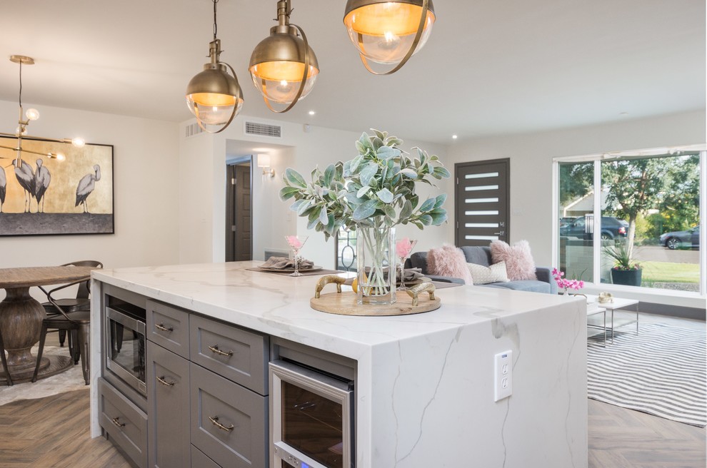 This is an example of a mid-sized midcentury galley eat-in kitchen in Phoenix with a farmhouse sink, shaker cabinets, grey cabinets, quartz benchtops, white splashback, cement tile splashback, stainless steel appliances, porcelain floors and with island.