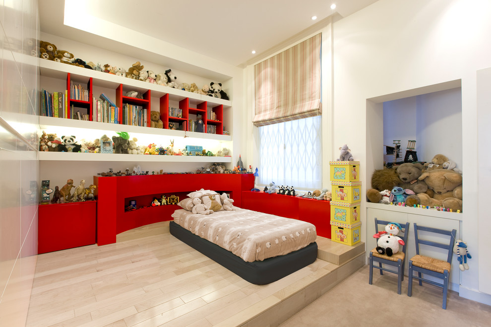 This is an example of a contemporary gender-neutral kids' room in London with beige walls, light hardwood floors and beige floor.