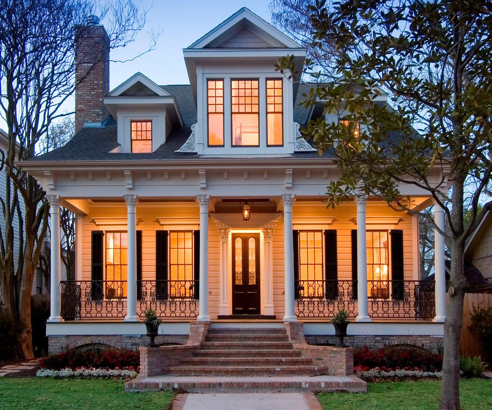 Expansive traditional two-storey white house exterior in Houston with wood siding, a clipped gable roof and a shingle roof.