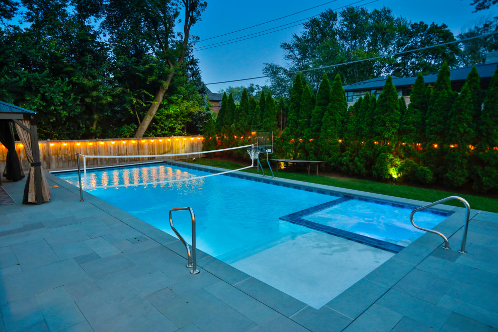 Idee per una piscina monocorsia chic rettangolare di medie dimensioni e dietro casa con pavimentazioni in pietra naturale