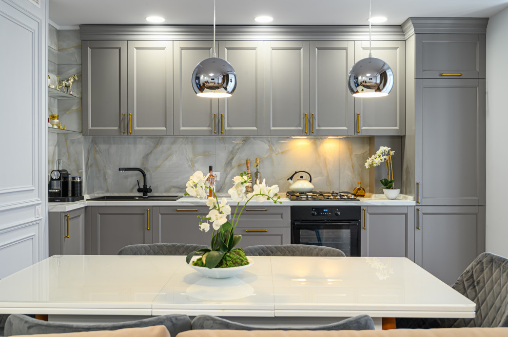 This is an example of a small modern l-shaped eat-in kitchen in Seattle with a drop-in sink, raised-panel cabinets, grey cabinets, multi-coloured splashback, black appliances and with island.
