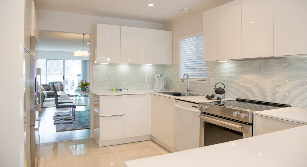 Photo of a mid-sized modern u-shaped kitchen in Vancouver with a drop-in sink, flat-panel cabinets, white cabinets, quartz benchtops, grey splashback, matchstick tile splashback, stainless steel appliances, porcelain floors, a peninsula and beige floor.
