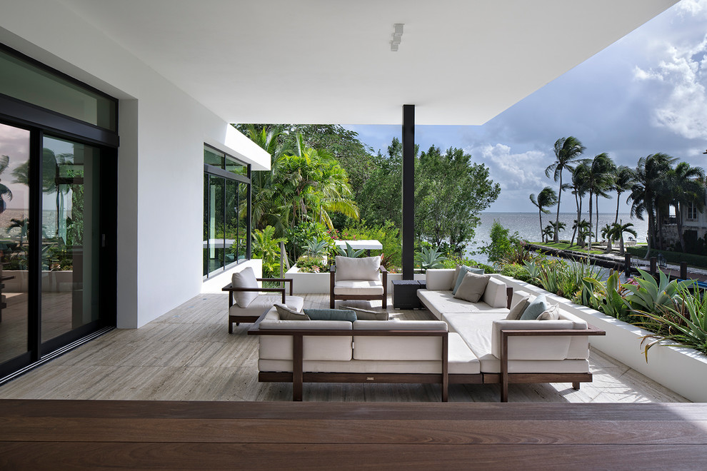 Inspiration for a mid-sized contemporary mixed material railing deck container garden remodel in Miami with a roof extension