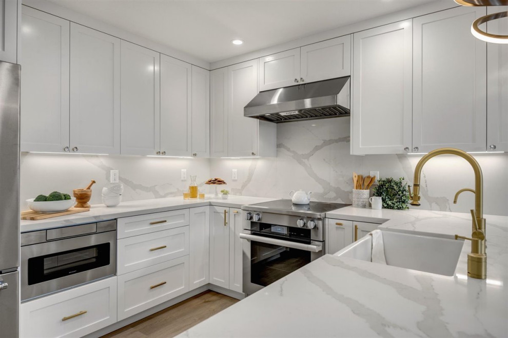 Eat-in kitchen - mid-sized modern u-shaped vinyl floor and beige floor eat-in kitchen idea in San Francisco with a farmhouse sink, shaker cabinets, white cabinets, quartz countertops, white backsplash, quartz backsplash, stainless steel appliances, a peninsula and white countertops