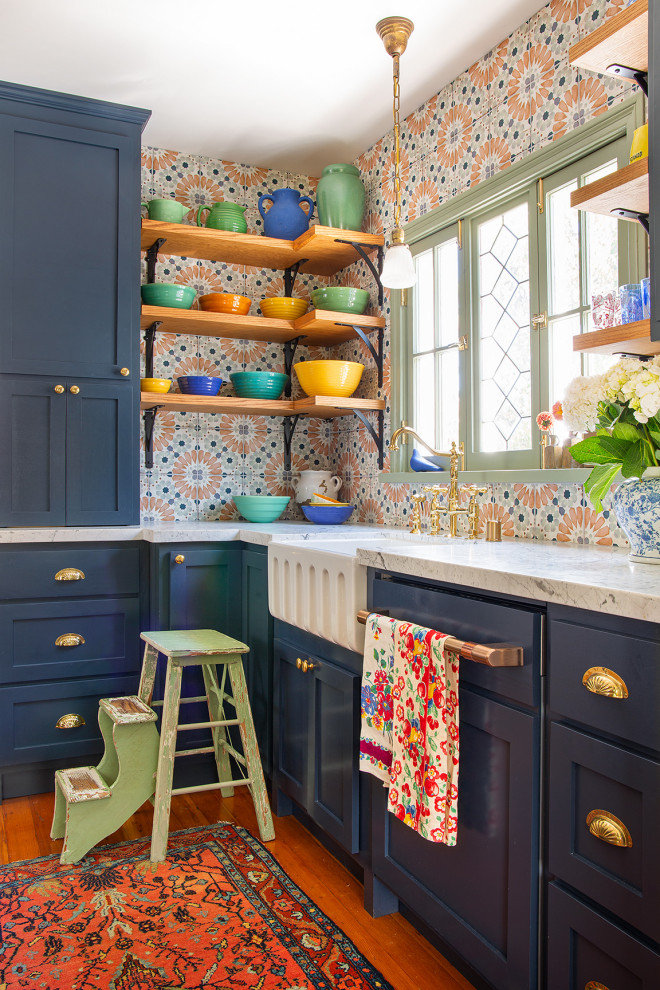 Photo of a mid-sized eclectic galley separate kitchen in Los Angeles with a farmhouse sink, shaker cabinets, blue cabinets, marble benchtops, multi-coloured splashback, porcelain splashback, white appliances, medium hardwood floors and white benchtop.