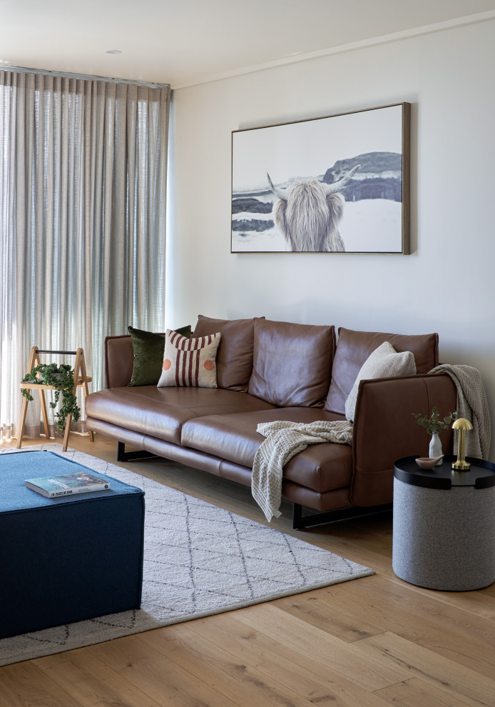 Kleines, Offenes Modernes Wohnzimmer mit weißer Wandfarbe, hellem Holzboden und TV-Wand in Melbourne