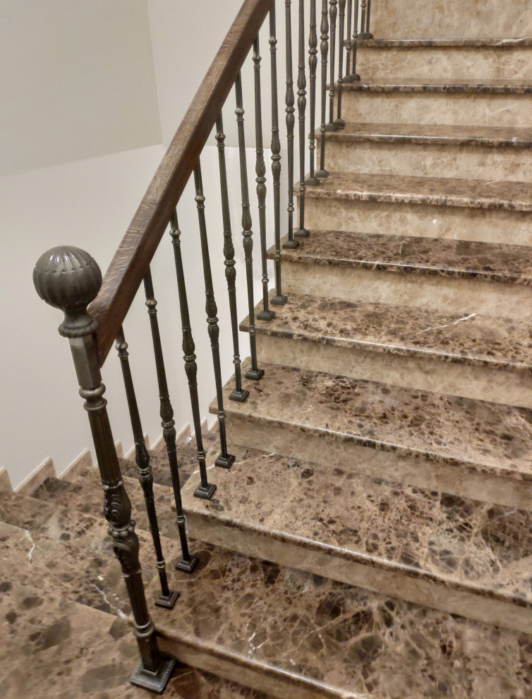 Traditional marble u-shaped staircase in Saint Petersburg with marble risers and metal railing.