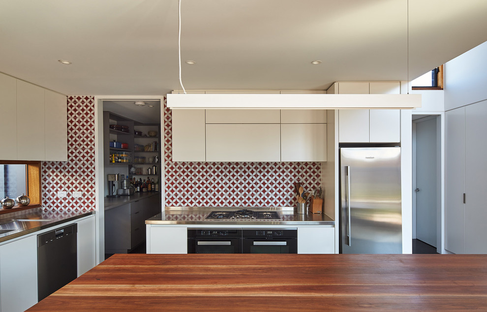 Design ideas for a mid-sized contemporary open plan kitchen in Melbourne with white cabinets, wood benchtops, red splashback and with island.