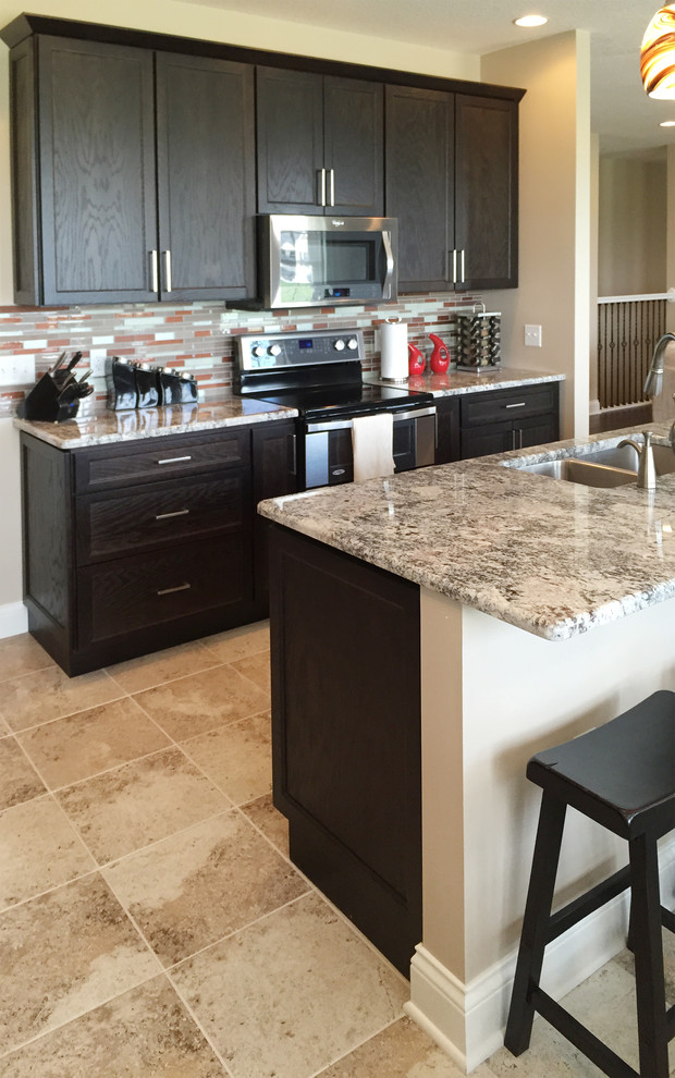 Mid-sized transitional l-shaped open concept kitchen photo with black cabinets, stainless steel appliances, an island, an undermount sink, recessed-panel cabinets and multicolored backsplash