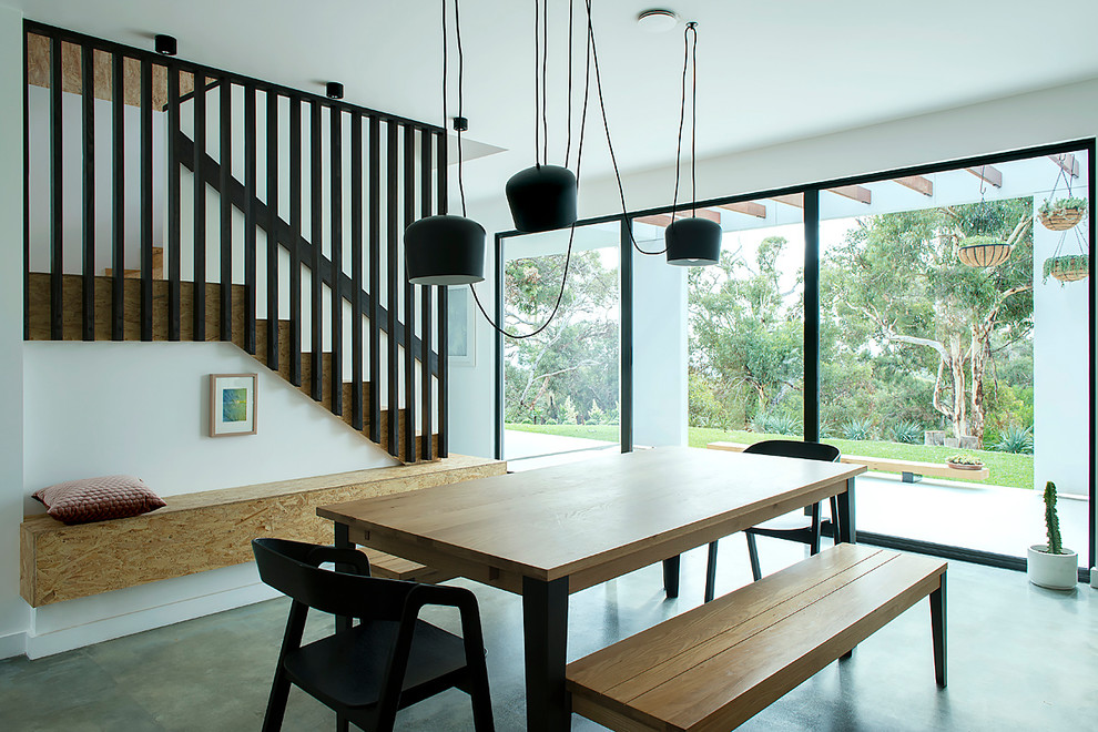 Inspiration for a mid-sized contemporary kitchen/dining combo in Perth with white walls, concrete floors and grey floor.