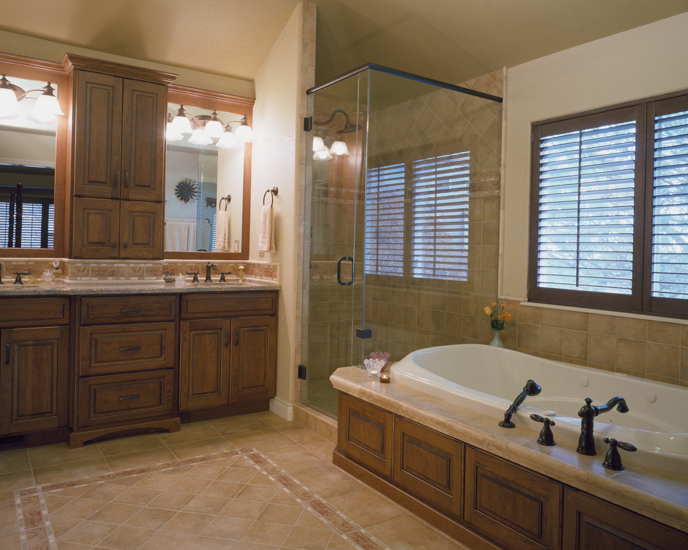 Mid-sized traditional master bathroom in Denver with an undermount sink, raised-panel cabinets, medium wood cabinets, a drop-in tub, a corner shower, beige tile, ceramic tile, beige walls and ceramic floors.