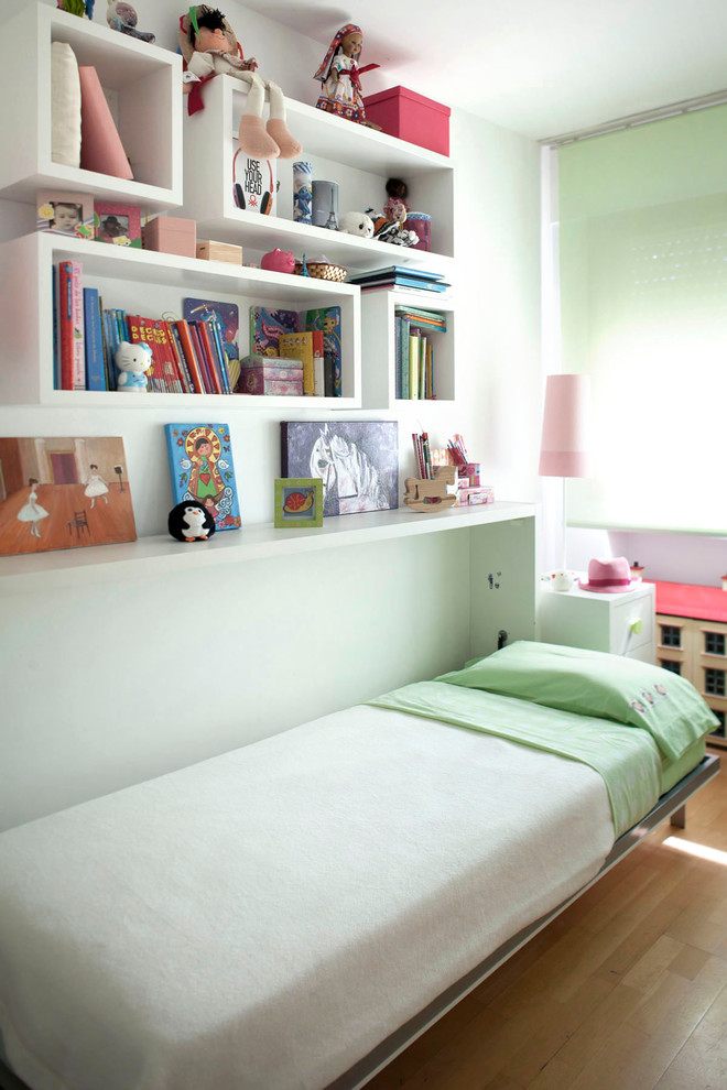 Mid-sized transitional kids' bedroom in Madrid with white walls and medium hardwood floors for kids 4-10 years old and girls.