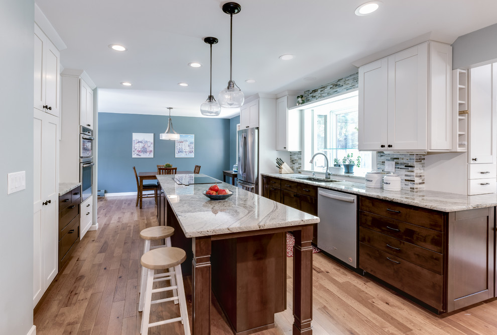 Inspiration for a mid-sized transitional galley medium tone wood floor and brown floor eat-in kitchen remodel in Denver with an undermount sink, shaker cabinets, white cabinets, granite countertops, blue backsplash, glass tile backsplash, stainless steel appliances, an island and beige countertops