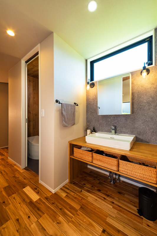 Idées déco pour un WC et toilettes asiatique de taille moyenne avec un placard sans porte, des portes de placard blanches, un mur gris, un sol en bois brun, un lavabo intégré, un sol marron, un plan de toilette marron, un plafond en papier peint et du papier peint.