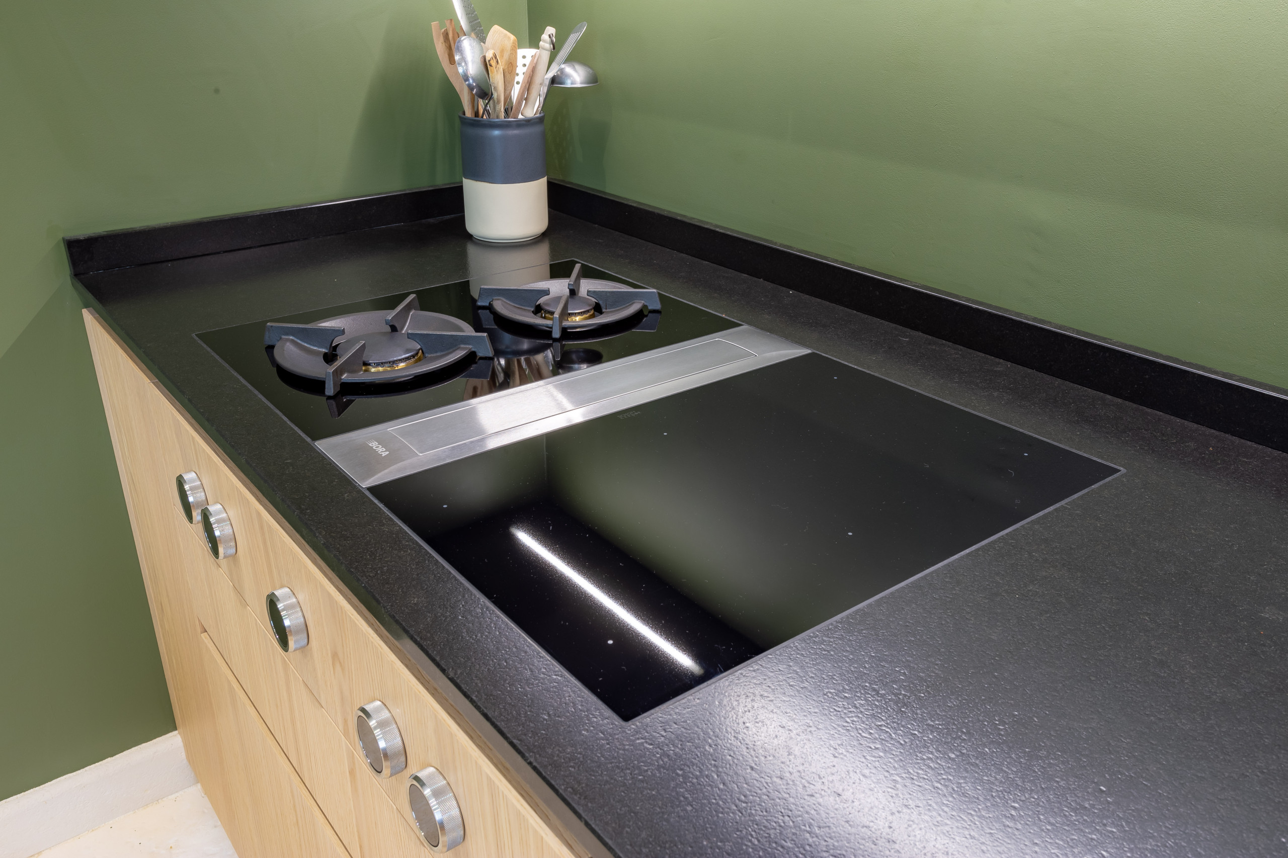 Réalisation d'une cuisine noire et bois dans un écrin végétal