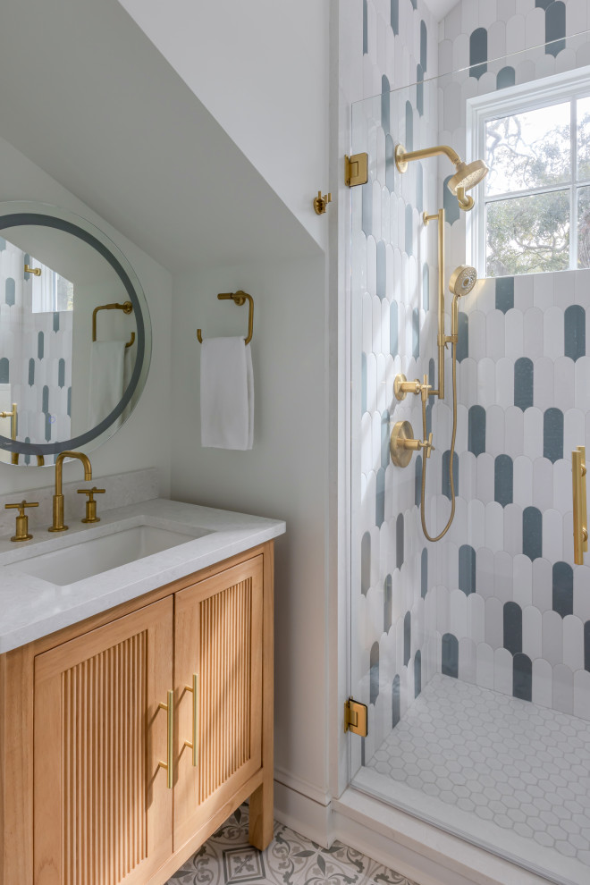 Example of a transitional multicolored tile multicolored floor and single-sink alcove shower design in Charleston with light wood cabinets, white walls, an undermount sink, a hinged shower door, white countertops and a freestanding vanity