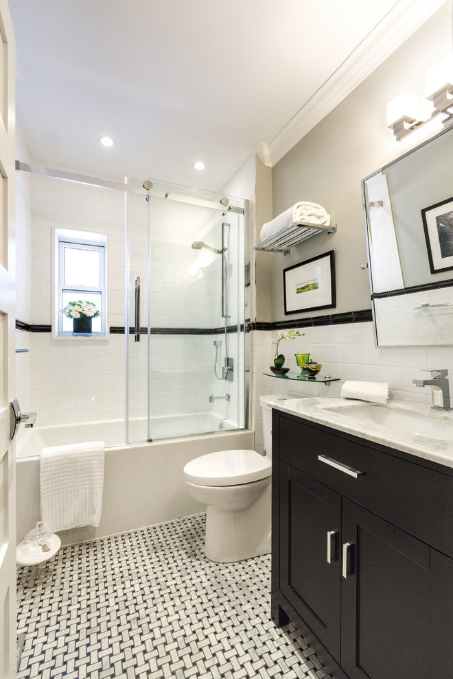 Photo of a small contemporary 3/4 bathroom in Other with shaker cabinets, dark wood cabinets, an alcove tub, a shower/bathtub combo, white tile, grey walls, marble benchtops, a two-piece toilet, subway tile, linoleum floors and a trough sink.
