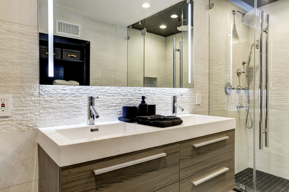 Пример оригинального дизайна: главная ванная комната среднего размера в стиле модернизм с плоскими фасадами, коричневыми фасадами, душем в нише, раздельным унитазом, бежевой плиткой, керамогранитной плиткой, белыми стенами, светлым паркетным полом, подвесной раковиной, столешницей из искусственного камня, бежевым полом, душем с распашными дверями, белой столешницей, нишей, тумбой под две раковины, подвесной тумбой и кессонным потолком