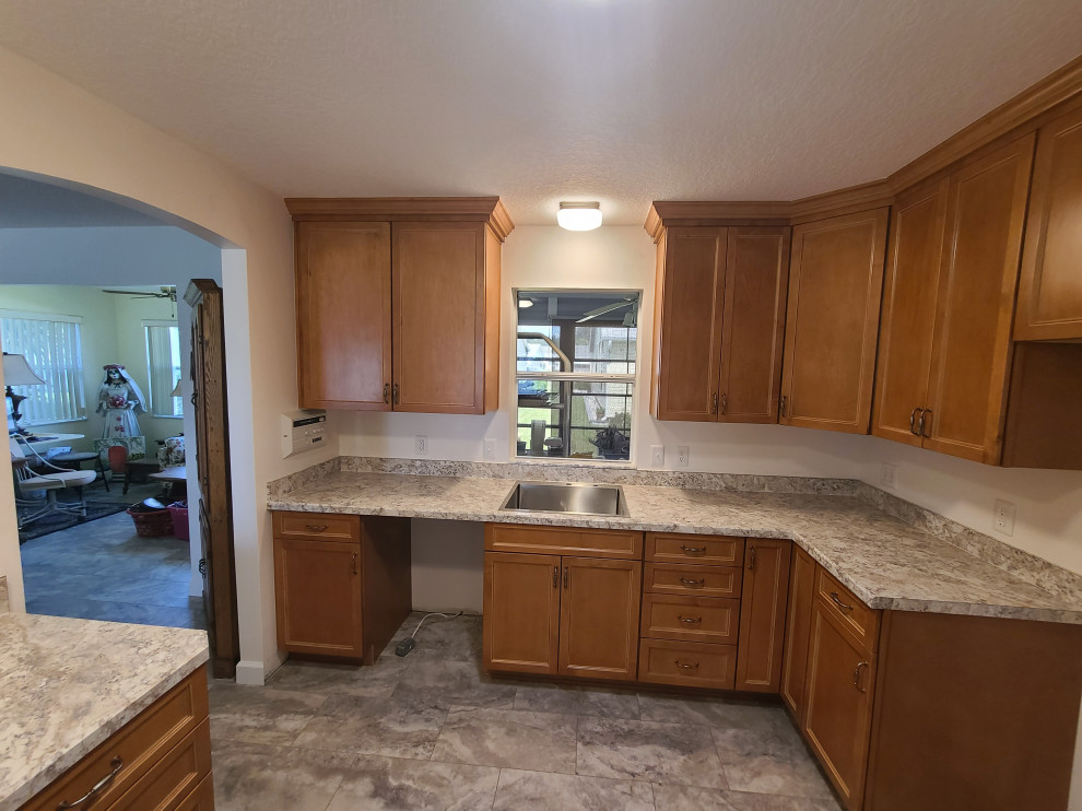 Inspiration for a mid-sized l-shaped eat-in kitchen remodel with flat-panel cabinets, medium tone wood cabinets, laminate countertops, an island and white countertops