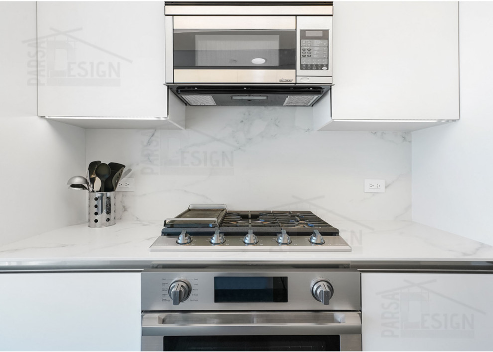Photo of a small modern galley separate kitchen in Los Angeles with a drop-in sink, flat-panel cabinets, white cabinets, quartz benchtops, white splashback, engineered quartz splashback, stainless steel appliances, light hardwood floors, no island, beige floor and white benchtop.