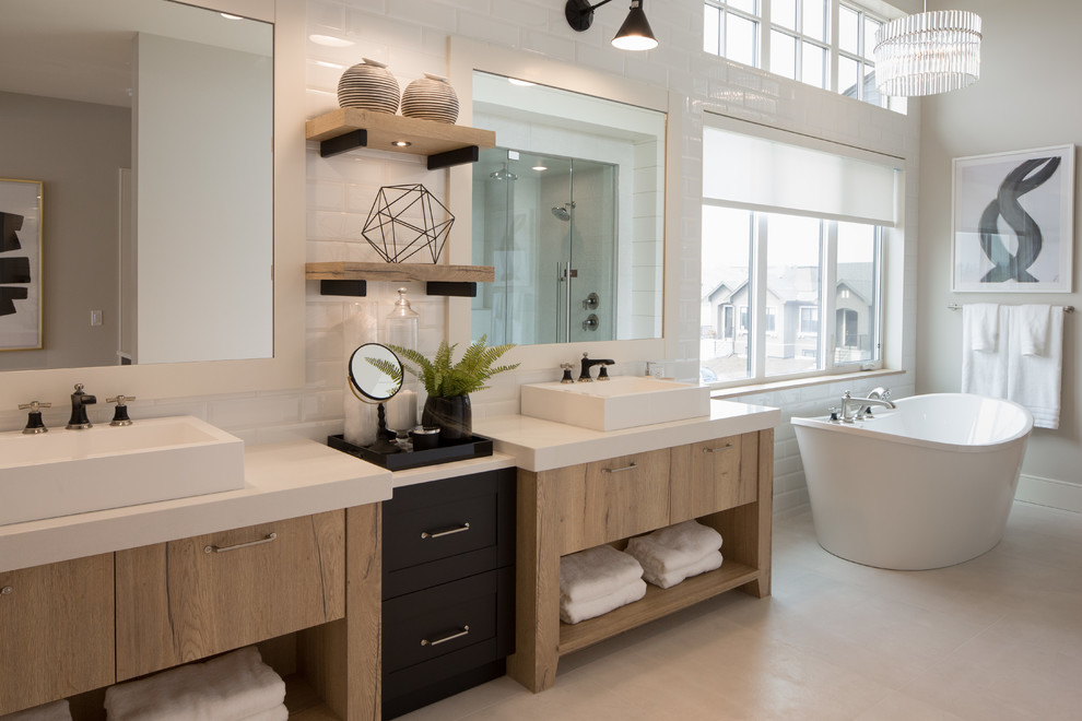 This is an example of an expansive country master bathroom in Calgary with medium wood cabinets, a freestanding tub, white tile, subway tile, white walls, porcelain floors, a vessel sink, engineered quartz benchtops, white floor, white benchtops and flat-panel cabinets.
