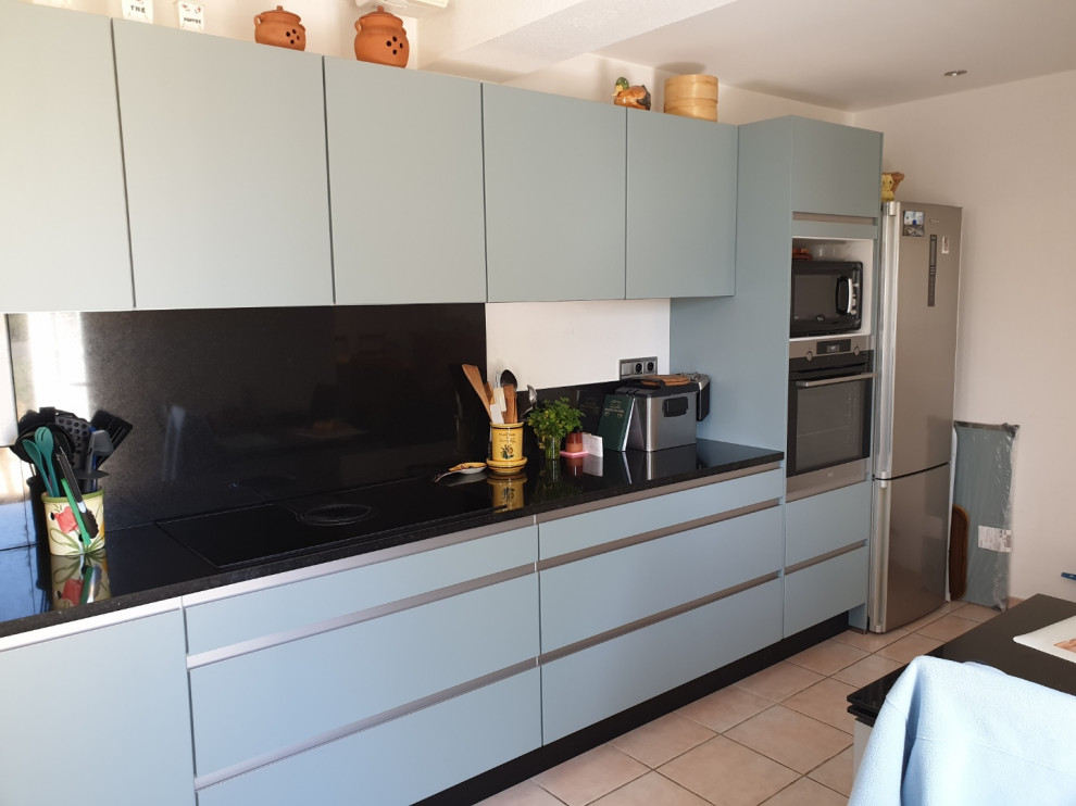 Large modern l-shaped separate kitchen in Toulouse with a single-bowl sink, beaded inset cabinets, green cabinets, granite benchtops, black splashback, granite splashback, panelled appliances, no island and black benchtop.