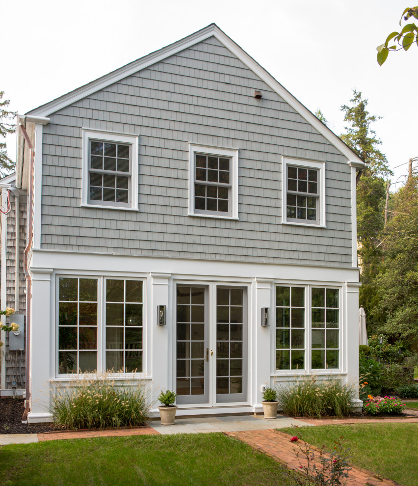 Photo of a large traditional two-storey grey house exterior in New York with wood siding, a grey roof and shingle siding.