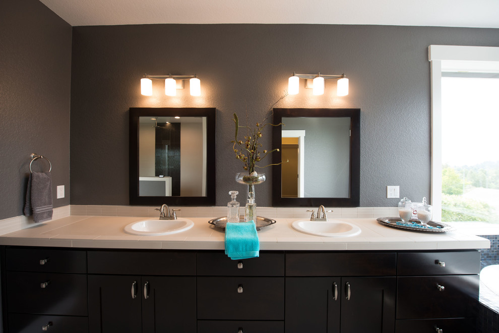 Inspiration for a large traditional master bathroom in Portland with shaker cabinets, dark wood cabinets, a freestanding tub, an alcove shower, a two-piece toilet, white tile, porcelain tile, grey walls, porcelain floors, a drop-in sink and tile benchtops.