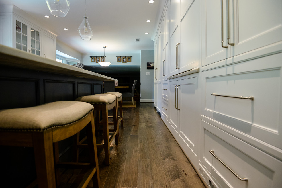 Eat-in kitchen - large transitional u-shaped medium tone wood floor and brown floor eat-in kitchen idea in DC Metro with recessed-panel cabinets, white cabinets, marble countertops, stainless steel appliances and an island