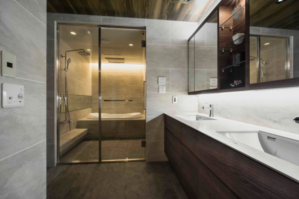 Modern bathroom in Tokyo with a built-in bath, beige tiles, beige walls, a submerged sink, beige floors, white worktops, double sinks, a built in vanity unit and a drop ceiling.