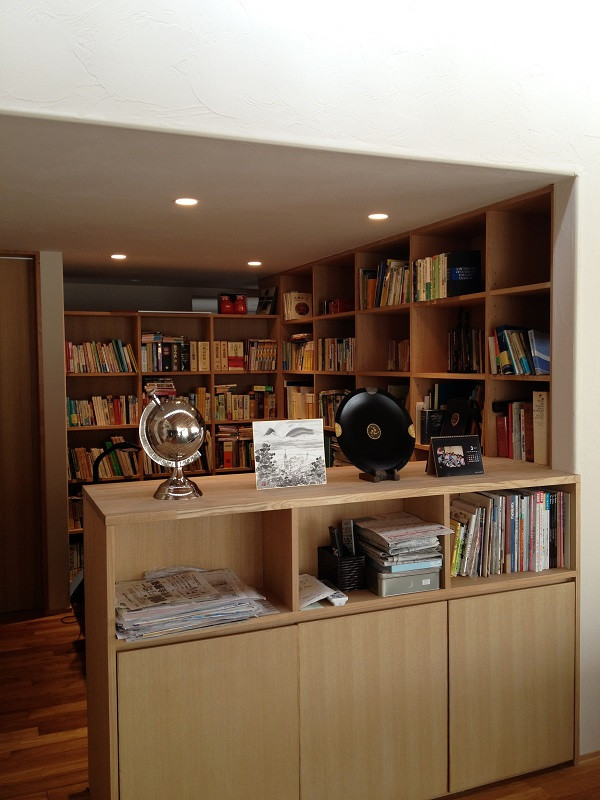 Cette photo montre un grand bureau avec un sol en bois brun et un bureau intégré.