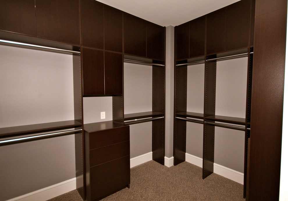 This is an example of a large traditional gender-neutral walk-in wardrobe in Edmonton with open cabinets, dark wood cabinets and carpet.