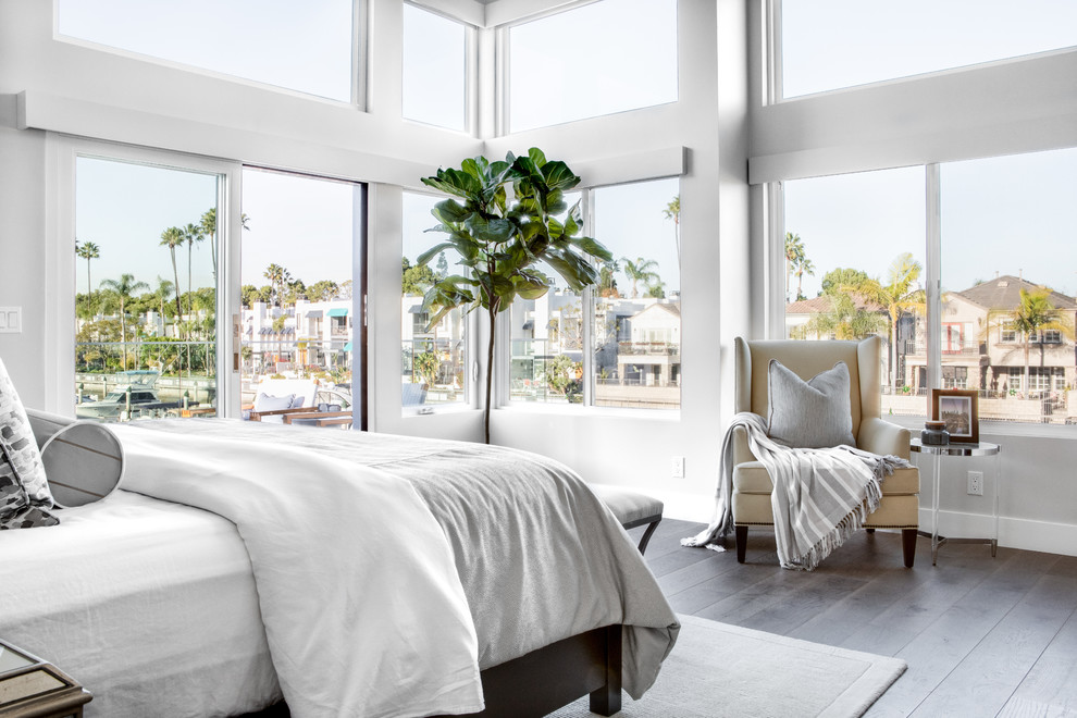 Photo of a mid-sized beach style master bedroom in Los Angeles with medium hardwood floors, brown floor and grey walls.