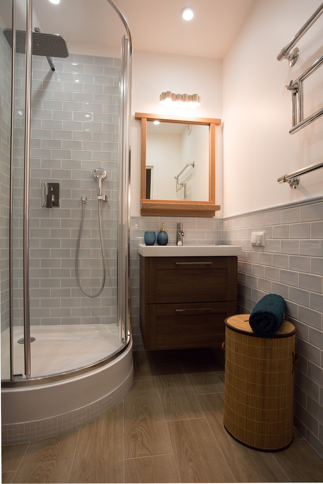 Cette image montre une salle de bain avec des portes de placard beiges, une douche d'angle, WC à poser, un carrelage bleu, des carreaux de céramique, un mur bleu, un sol en carrelage de céramique et un plan vasque.