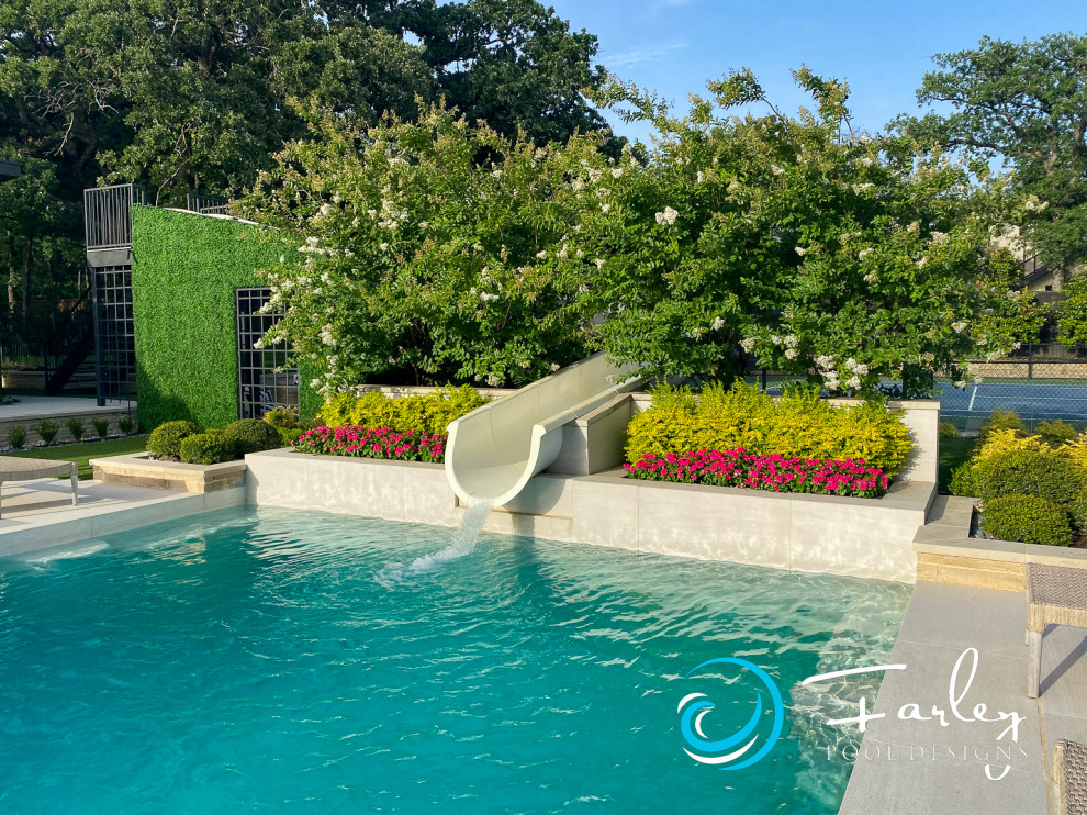 Foto di una grande piscina monocorsia minimalista personalizzata dietro casa con un acquascivolo e piastrelle