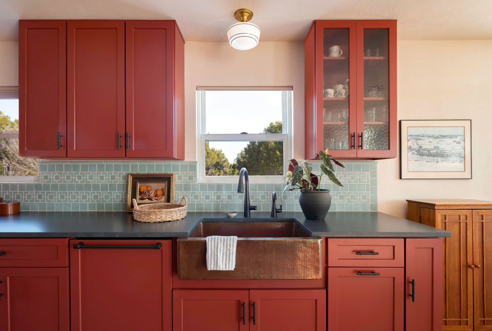 Design ideas for a mid-sized eclectic galley eat-in kitchen in Austin with a farmhouse sink, shaker cabinets, red cabinets, quartz benchtops, blue splashback, ceramic splashback and black benchtop.