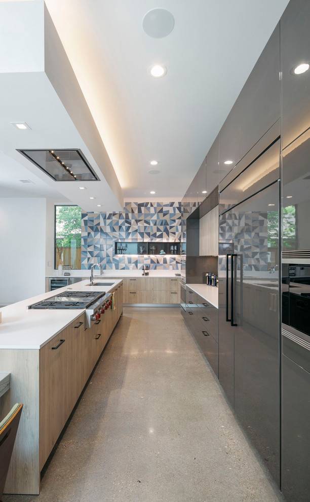 Photo of a mid-sized contemporary galley kitchen in Houston with an undermount sink, flat-panel cabinets, grey cabinets, quartz benchtops, multi-coloured splashback, ceramic splashback, stainless steel appliances, concrete floors, with island, grey floor and white benchtop.