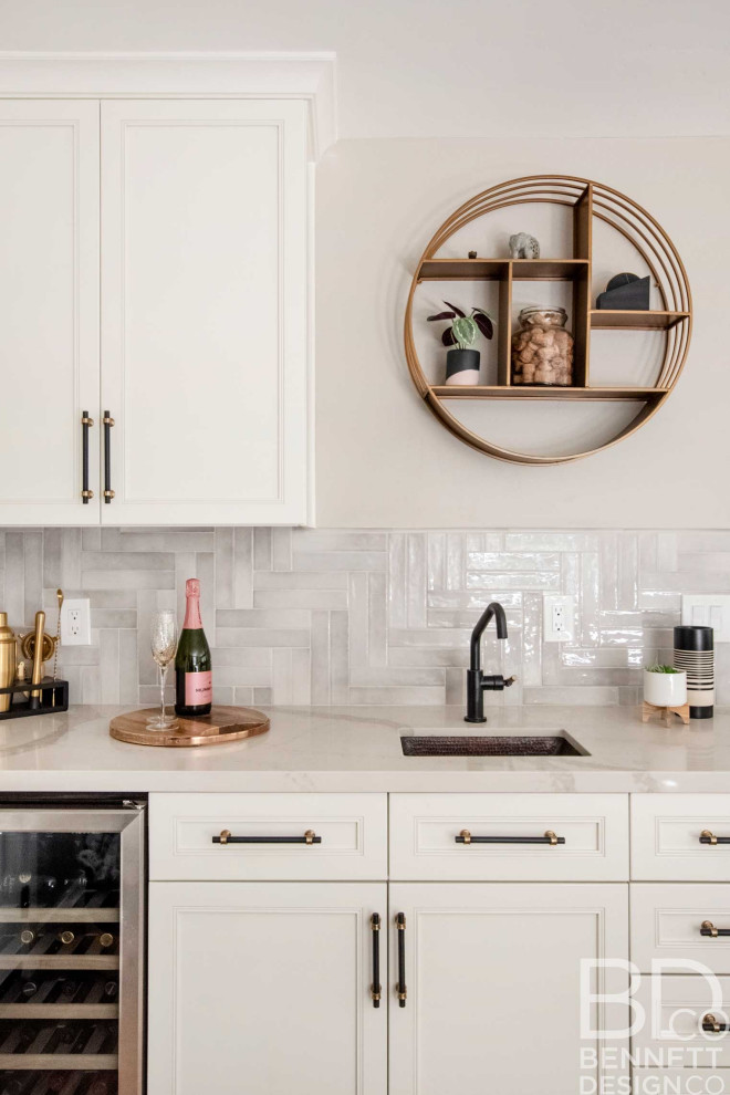 Photo of a mid-sized country single-wall wet bar in San Francisco with an undermount sink, recessed-panel cabinets, white cabinets, quartz benchtops, beige splashback, porcelain splashback, light hardwood floors, beige floor and white benchtop.