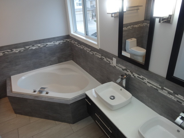 Design ideas for a mid-sized contemporary master bathroom in Toronto with a vessel sink, a corner tub, an alcove shower, a one-piece toilet, recessed-panel cabinets, dark wood cabinets, solid surface benchtops, gray tile, porcelain tile, white walls and porcelain floors.