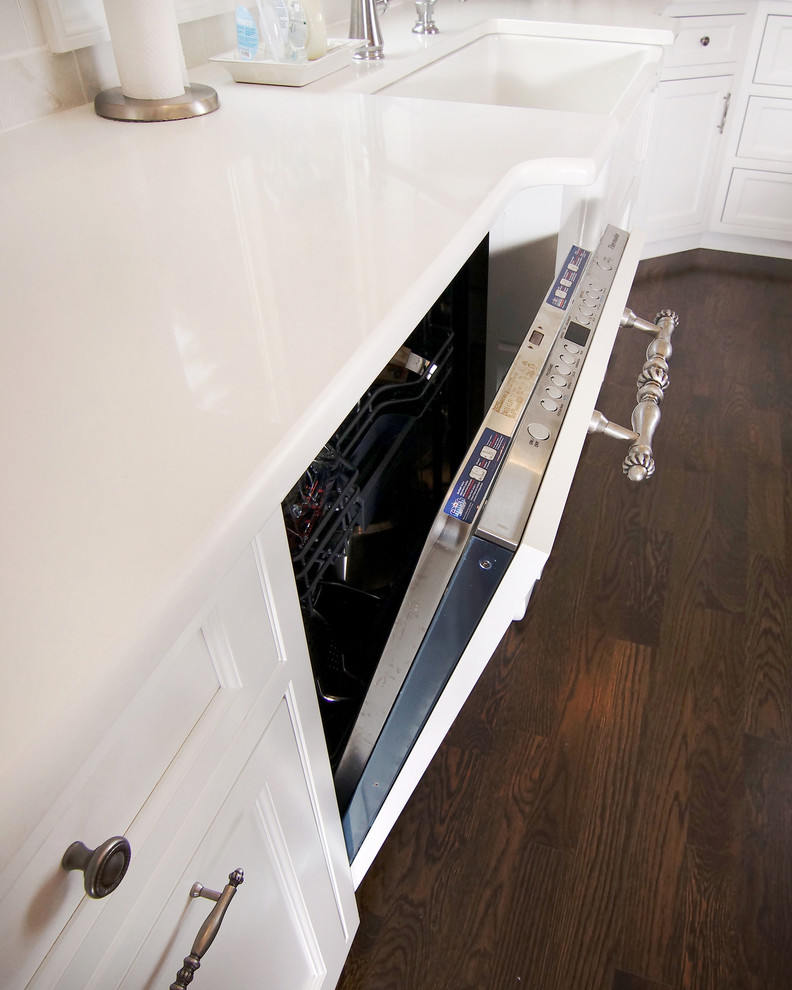 Eat-in kitchen - large transitional u-shaped dark wood floor eat-in kitchen idea in New York with white cabinets, white backsplash, an island, a farmhouse sink, beaded inset cabinets, subway tile backsplash and paneled appliances