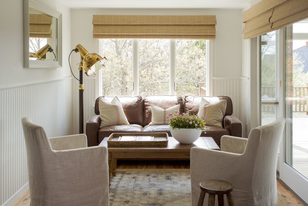 Example of a beach style enclosed medium tone wood floor living room design in Boston with white walls, no fireplace and no tv