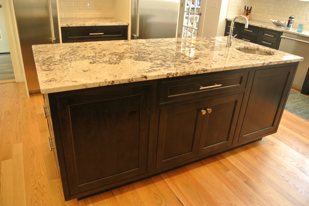 Inspiration for a transitional light wood floor eat-in kitchen remodel in Boston with an undermount sink, shaker cabinets, granite countertops, white backsplash, subway tile backsplash, stainless steel appliances and an island