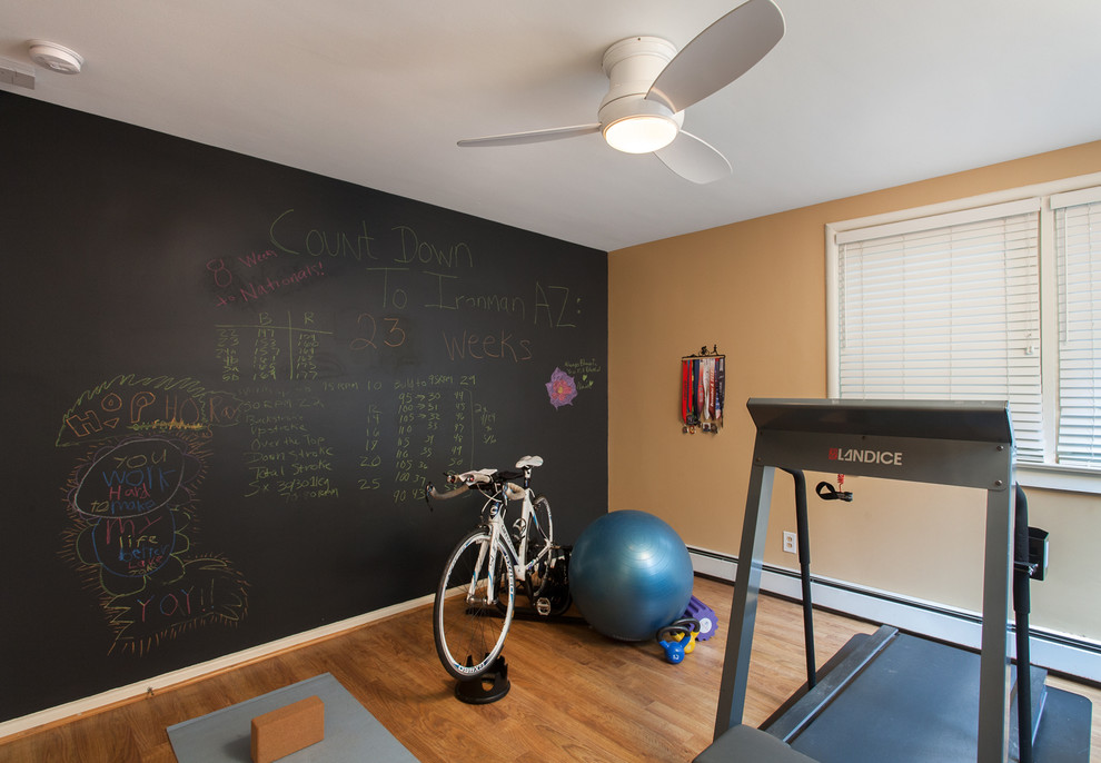 Design ideas for a mid-sized arts and crafts home weight room in DC Metro with yellow walls and medium hardwood floors.