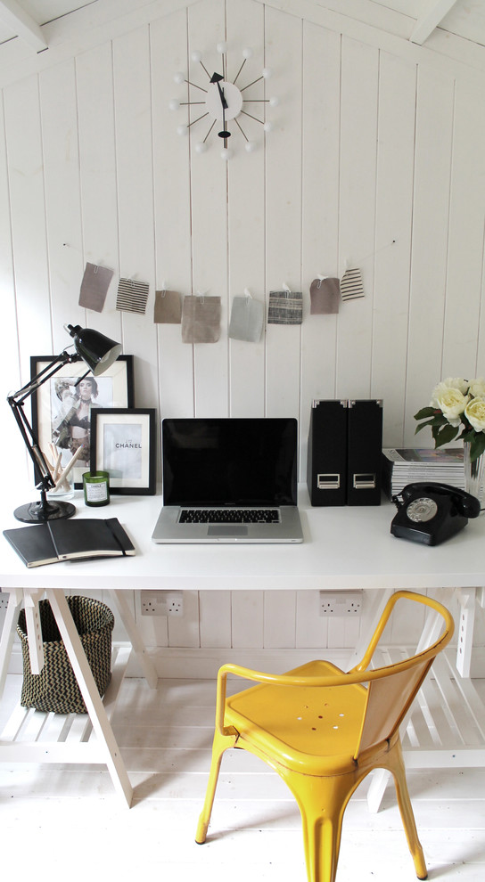Small scandinavian study room in London with white walls, painted wood floors, a freestanding desk and white floor.