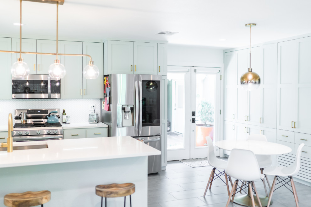 Medium sized retro u-shaped kitchen/diner in Other with a built-in sink, shaker cabinets, green cabinets, engineered stone countertops, white splashback, mosaic tiled splashback, stainless steel appliances, porcelain flooring, a breakfast bar, grey floors and white worktops.