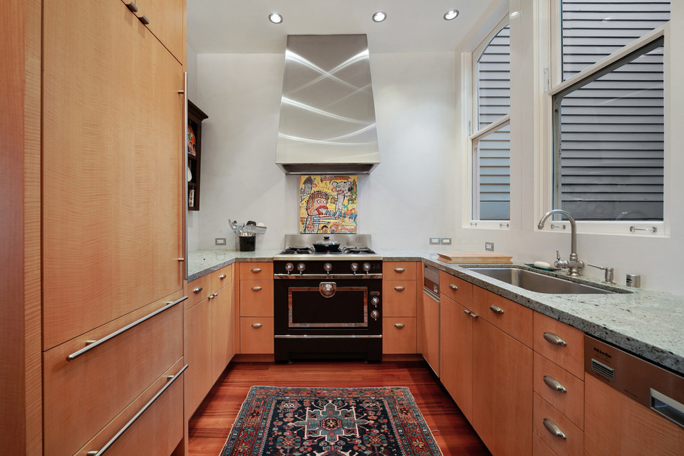 Small eclectic u-shaped separate kitchen in San Francisco with an undermount sink, flat-panel cabinets, medium wood cabinets, marble benchtops, black appliances, medium hardwood floors, no island, brown floor and grey benchtop.