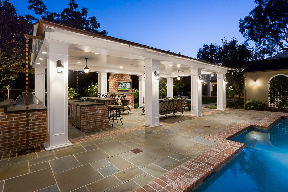 Design ideas for a traditional backyard patio in Los Angeles with natural stone pavers and a gazebo/cabana.