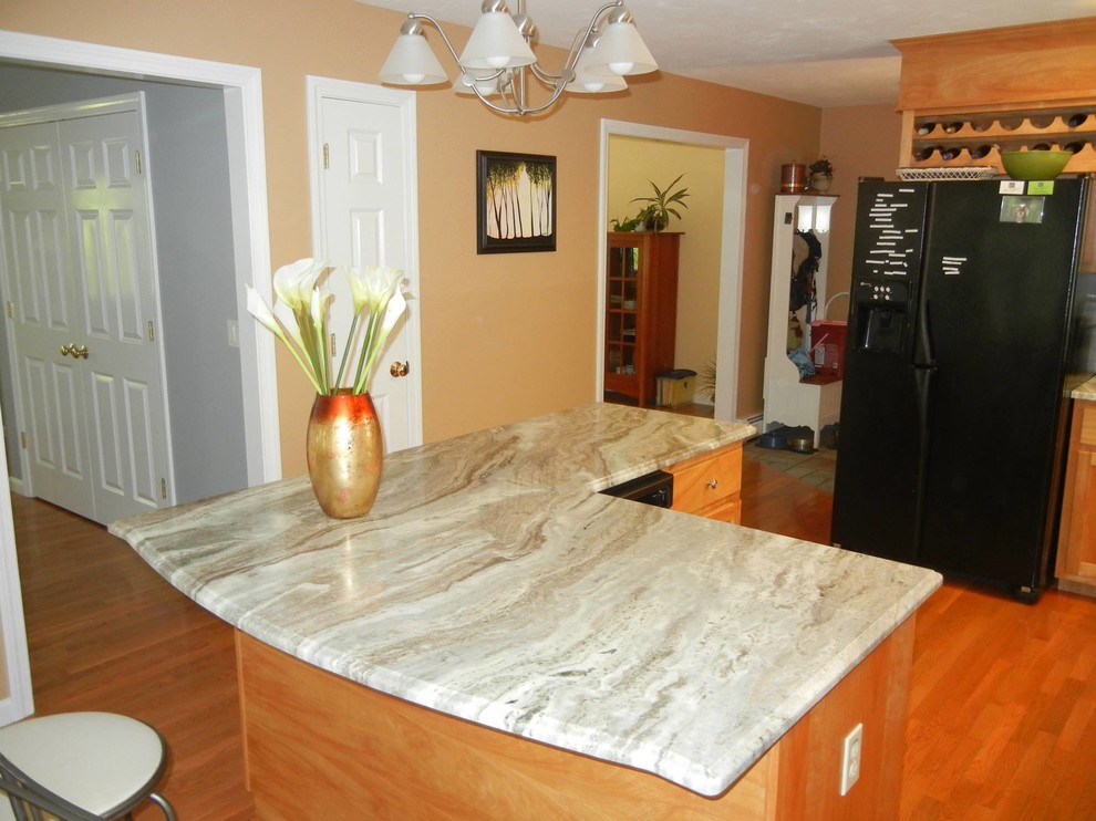 Inspiration for a mid-sized transitional l-shaped medium tone wood floor and brown floor open concept kitchen remodel in Providence with recessed-panel cabinets, medium tone wood cabinets, granite countertops, black appliances, an island and beige countertops